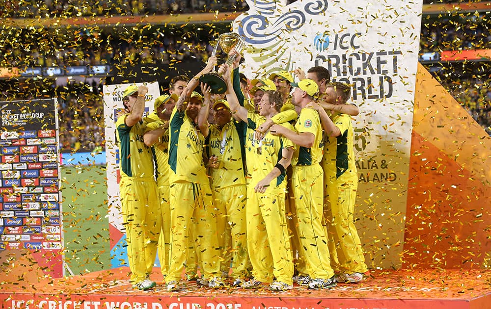 Australian captain Michael Clarke holds the trophy aloft with his teammates as they celebrate their seven wicket win over New Zealand in the Cricket World Cup final in Melbourne, Australia.