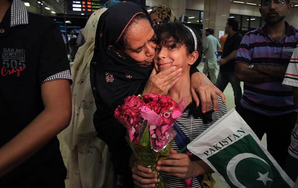 A Pakistan girl, who with her family members evacuated from Yemen, is greeted by her relatives upon their family arrival in Jinnah International Airport in Karachi, Pakistan.