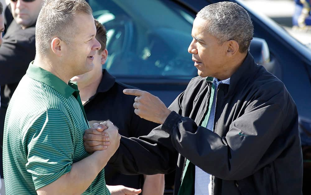 President Barack Obama, right, talks to Scott Van Duzer, left, on the tarmac of St. Lucie International Airport before boarding Air Force One, in Fort Pierce, Fla.