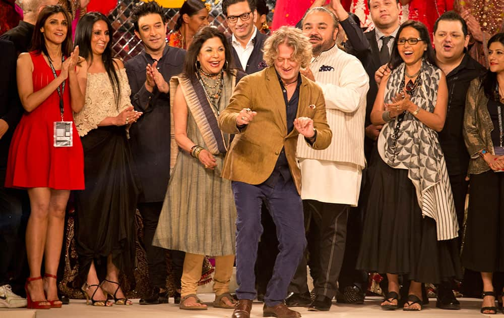 Indian designer Rohit Bal, center, dances as other designers watch during the grand finale of Amazon India fashion Week.