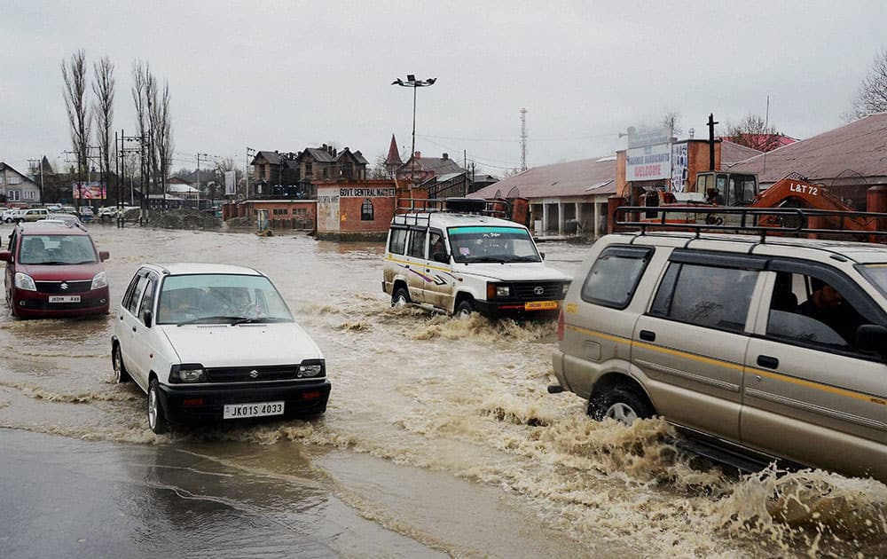 Vehicles wade through a waterlogged road after the valley received heavy rainfall, in Srinagar.