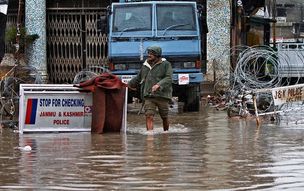 A  paramilitary soldier walks through a flooded street following heavy rains in Srinagar.