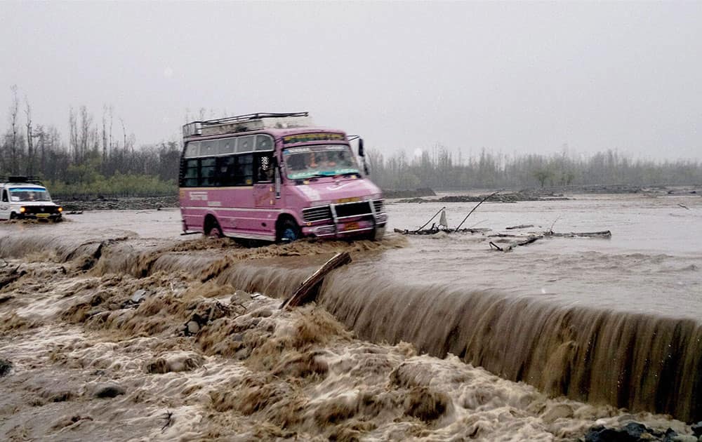 VEHICLES PASS THROUGH SUBMERGED BRIDGE IN A FLOODED LARKIPORA AREA.