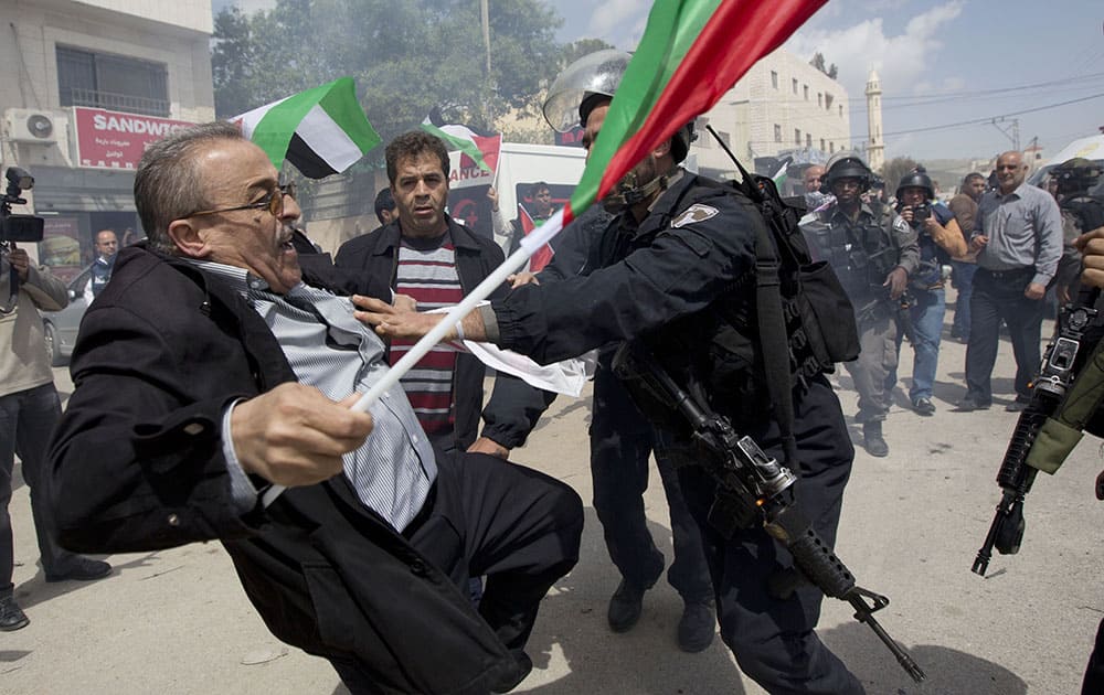 Palestinians protester is pushed by Israeli border policemen during a protest marking the Land Day in the West Bank village of Hawara near Nablus. Land Day commemorates riots on March 30, 1976, when six people were killed during a protest by Israeli Arabs whose property was annexed in northern Israel to expand Jewish communities. 