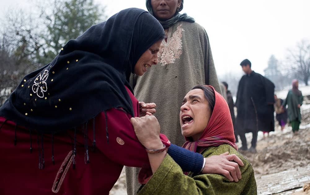 An unidentified woman, left, comforts a relative of landslide victims in village of Laden some 45 Kilometers (28 miles) west of Srinagar, India.