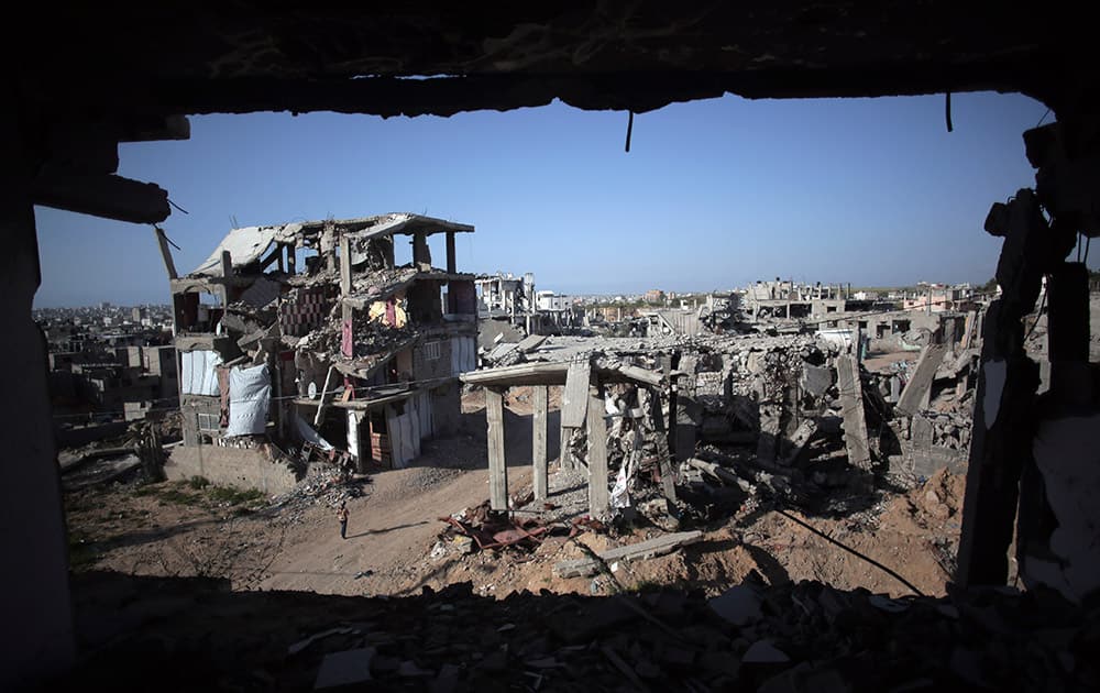 A Palestinian girl walks next to destroyed houses, in the Shijaiyah neighborhood of Gaza City.