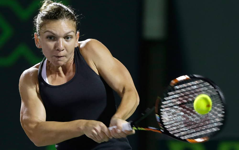 Simona Halep, of Romania, returns to Flavia Pennetta at the Miami Open tennis tournament.