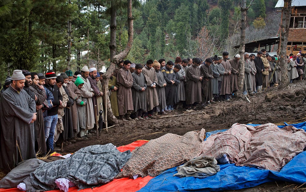 Muslim villagers pray by the bodies of landslide victims during a joint funeral in the village of Laden, some 45 kilometers (28 miles) west of Srinagar, India.