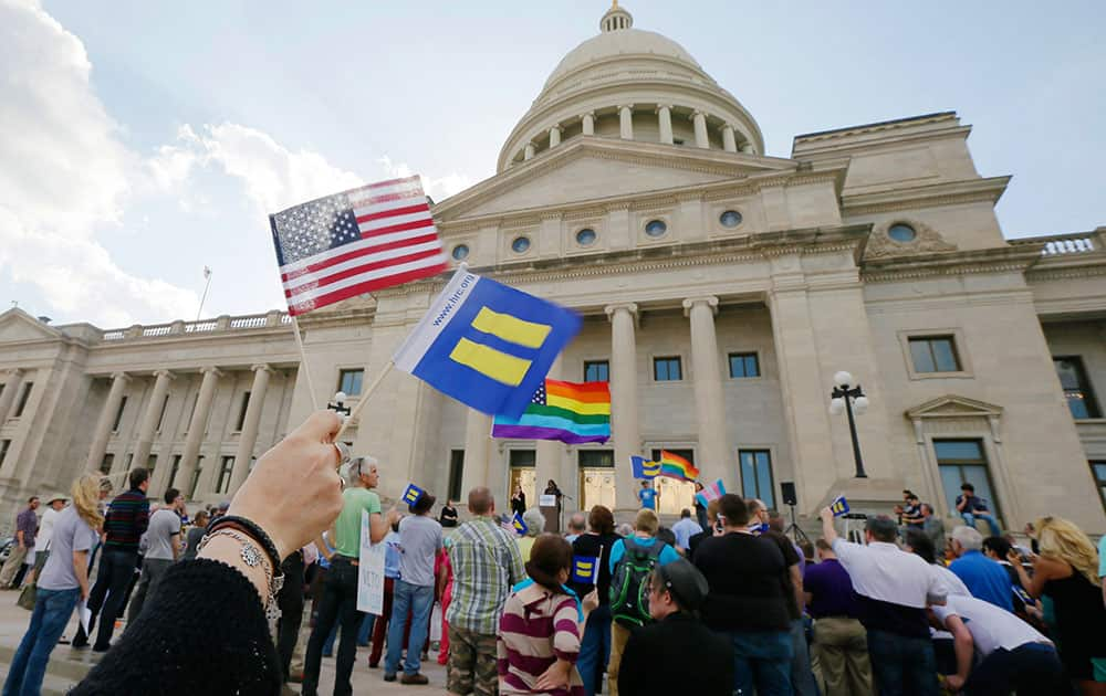 Demonstrators wave flags as they attend a rally at the Arkansas state Capitol in Little Rock, Ark., in protest of a bill passed by the state House critics say will lead to discrimination against gays and lesbians.