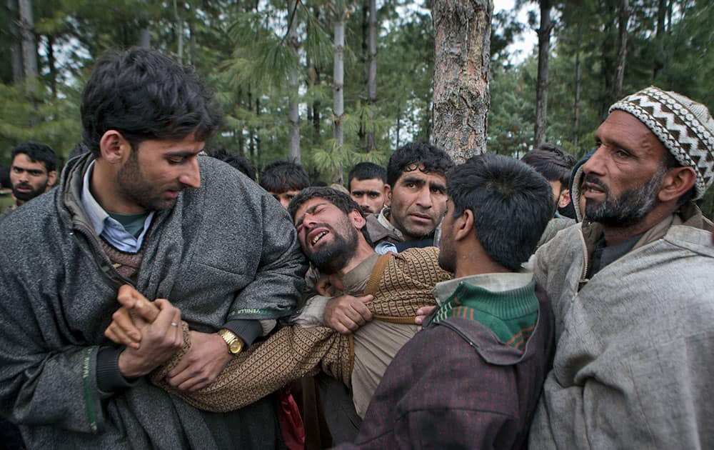 Muslim villagers comfort a relative of a landslide victim during a joint funeral in the village of Laden, some 45 kilometers (28 miles) west of Srinagar, India.