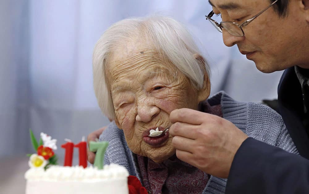 FILE - In this March 5, 2015 file photo, Japan's Misao Okawa who is recognized as the world's oldest living person by Guinness World Records, eats cake, helped by her nursing home staff member, during her 117th birthday celebration event at a nursing home in Osaka, western Japan. Okawa died Wednesday, April 1, 2015, a few weeks after celebrating her 117th birthday.