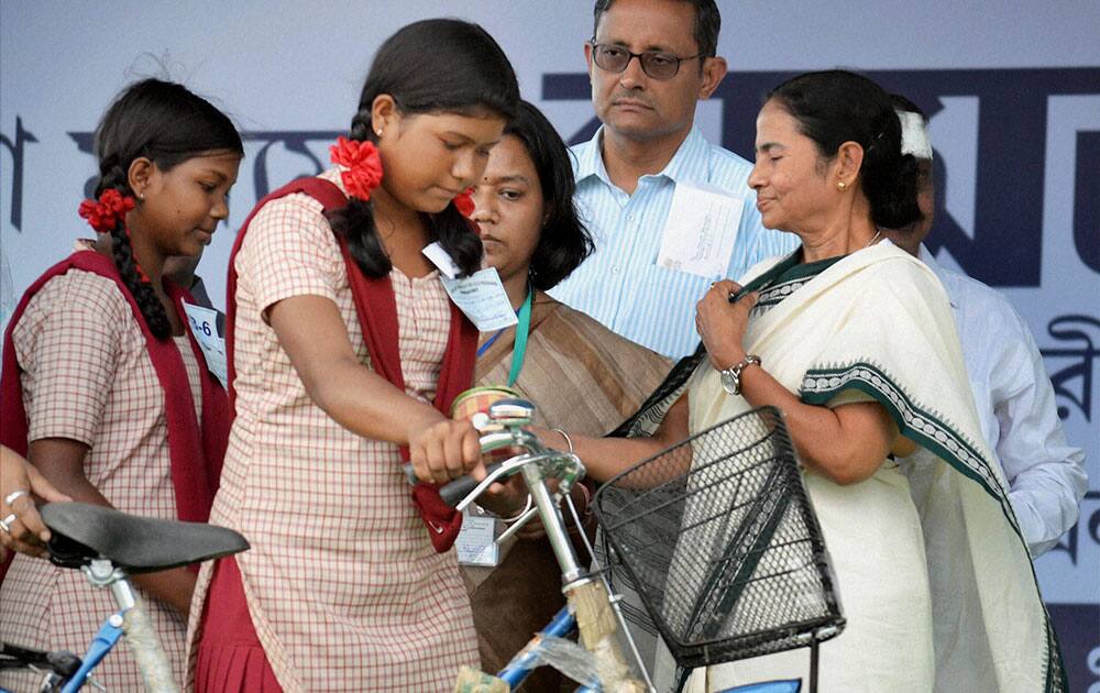 West Bengal Chief Minister Mamata Banerjee presenting bicycles to girl students under a government programme at Birpara in Alipurduar district of West Bengal.