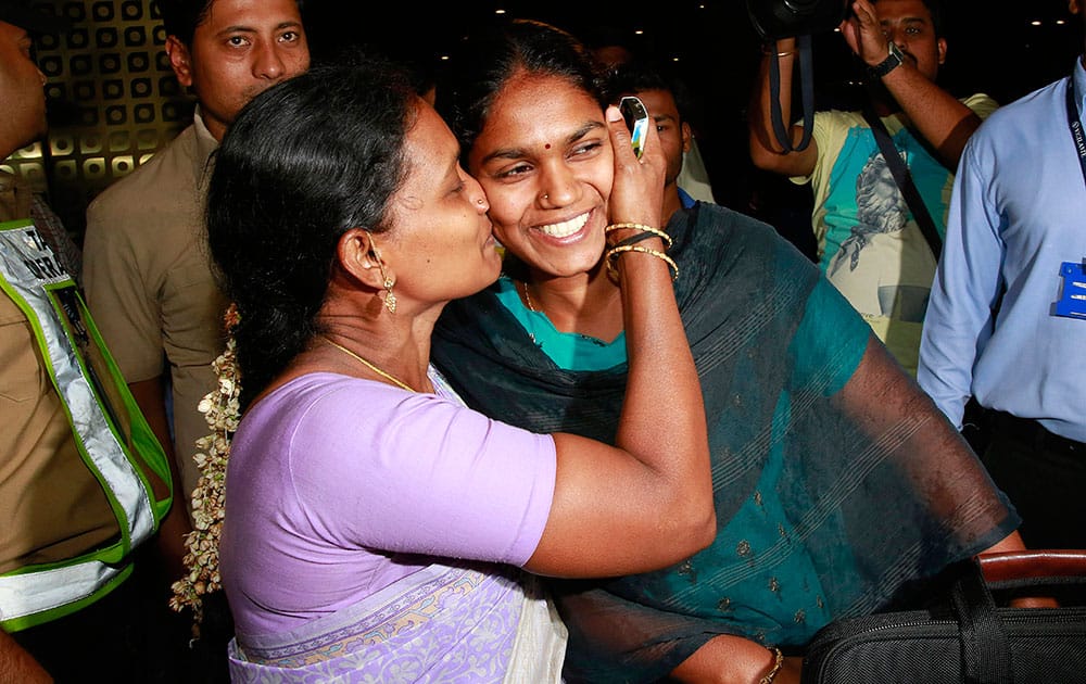 A woman greets her relative who arrived at Chhatrapati Shivaji International Airport in Mumbai.