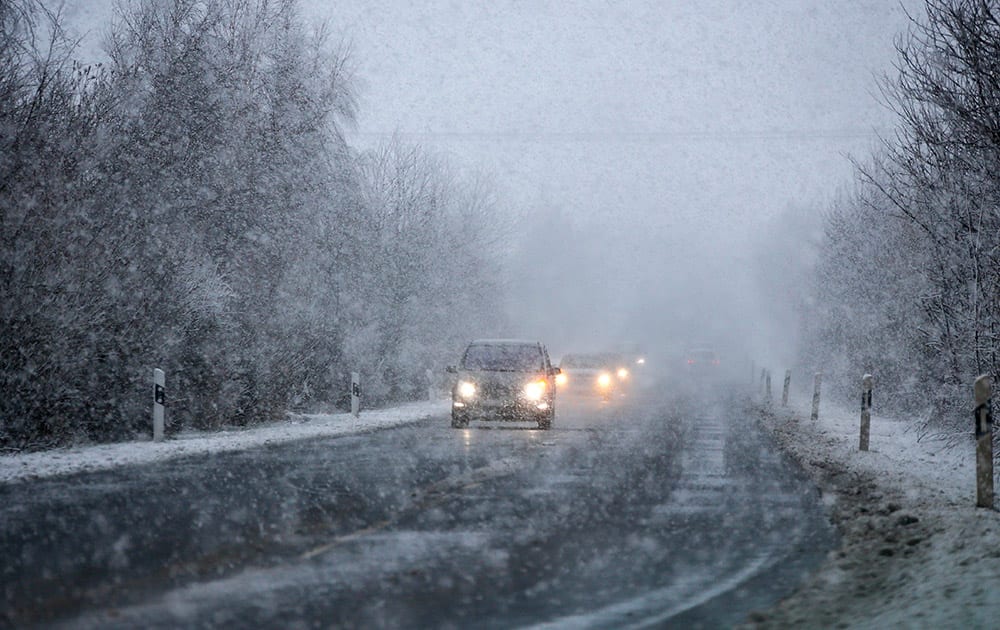 Cars drive through heavy snowfall near Wernigerode, eastern Germany.