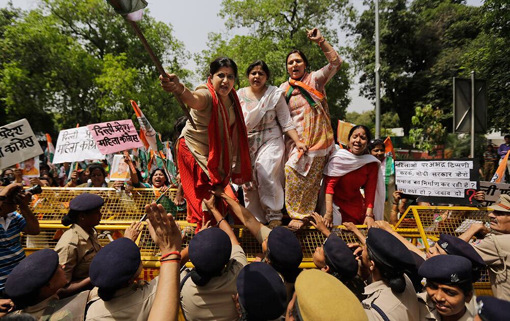 Activists of India’s opposition Congress party’s women’s wing climb police barricades and shout slogans against the ruling Bharatiya Janata Party (BJP) during a protest outside the BJP headquarters in New Delhi.
