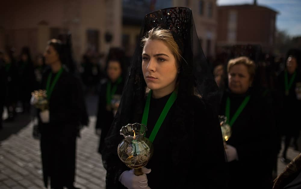 Penitents of the 'Virgen de la Esperanza' brotherhood dressed in the traditional suit La Mantilla (the mantle), march as they take part in a Holy Week procession in Zamora, Spain.