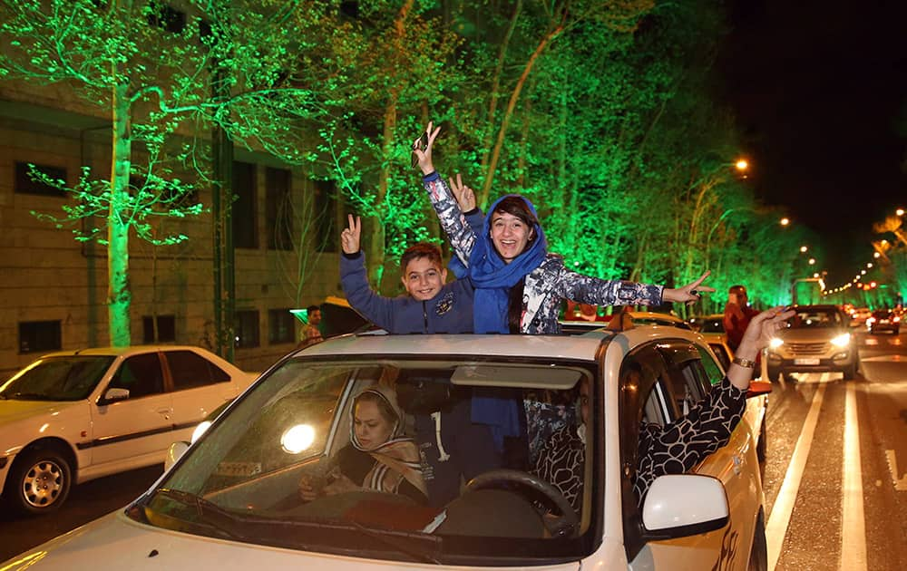 Iranians flash the victory sign from their car while celebrating at a street in northern Tehran, Iran.