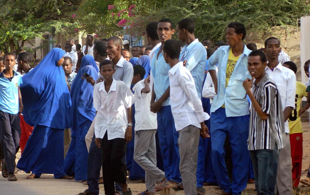 Students gather and watch from a distance outside the Garissa University College after an attack by gunmen, in Garissa, Kenya.