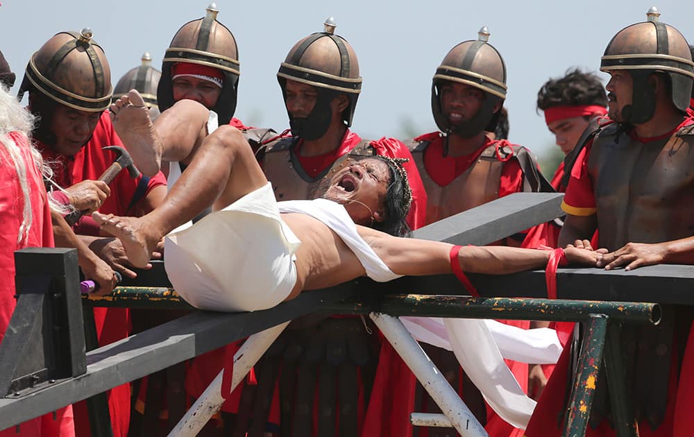 Filipino devotee Ruben Enaje screams as he is nailed to the cross for the 29th time during Good Friday rituals at Cutud, Pampanga province, northern Philippines. 