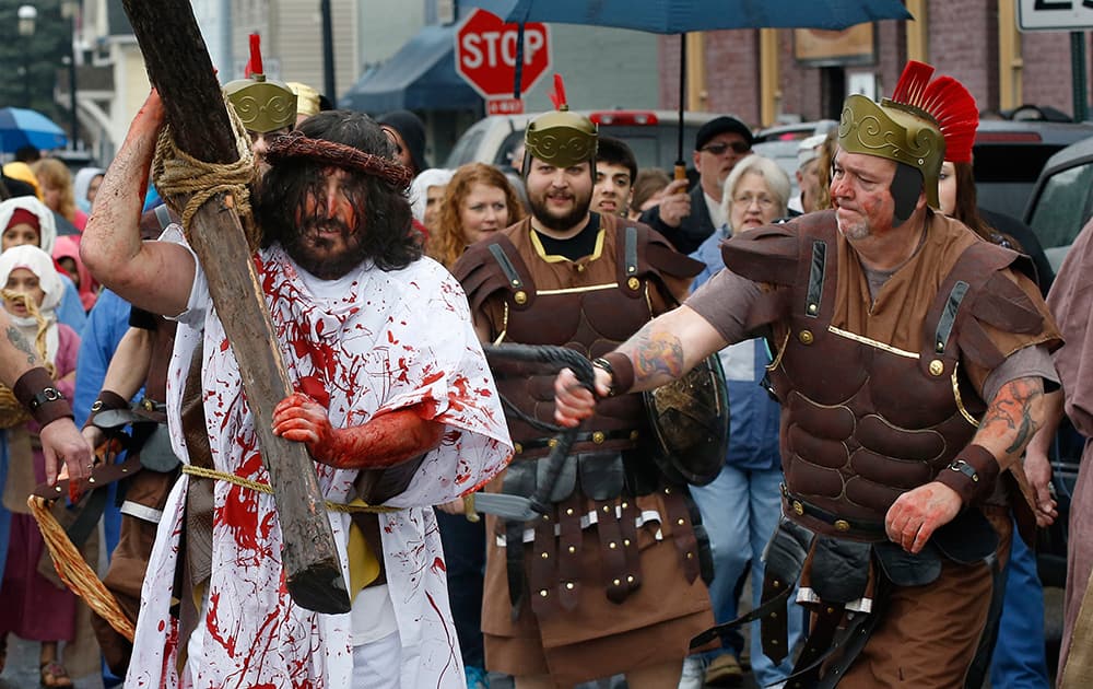 A volunteer from the Bridgewater Community Churches portraying a Roman Centurion, whips the man portraying Jesus as they perform a reenactment of the crucifixion of Jesus on Good Friday, in Bridgewater, Pa.