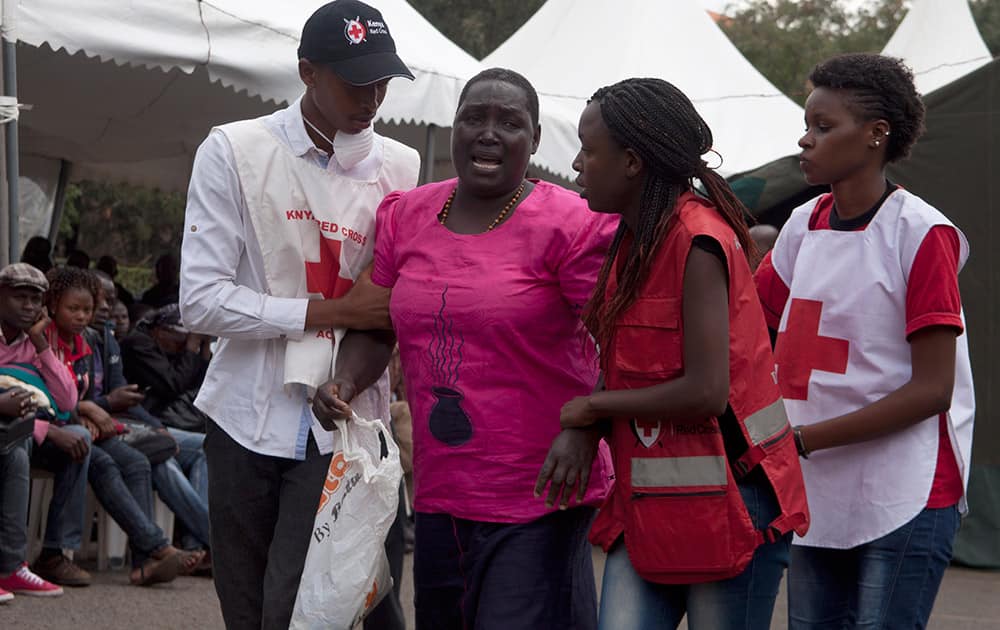 Red Cross staff console a woman after she viewed the body of a relative killed in Thursday's attack on a university, at Chiromo funeral home, Nairobi, Kenya.