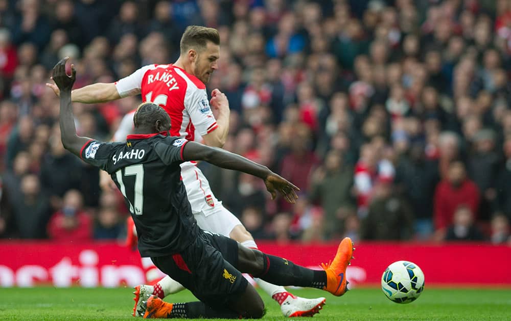 Arsenal's Aaron Ramsey tries to score past Liverpool's Mamadou Sakho during their English Premier League soccer match at Emirates Stadium, in London.