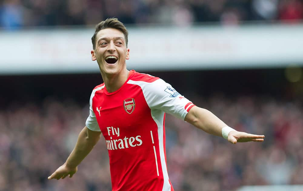 Arsenal's Mesut Özil celebrates after scoring against Liverpool during their English Premier League soccer match at Emirates Stadium, in London.