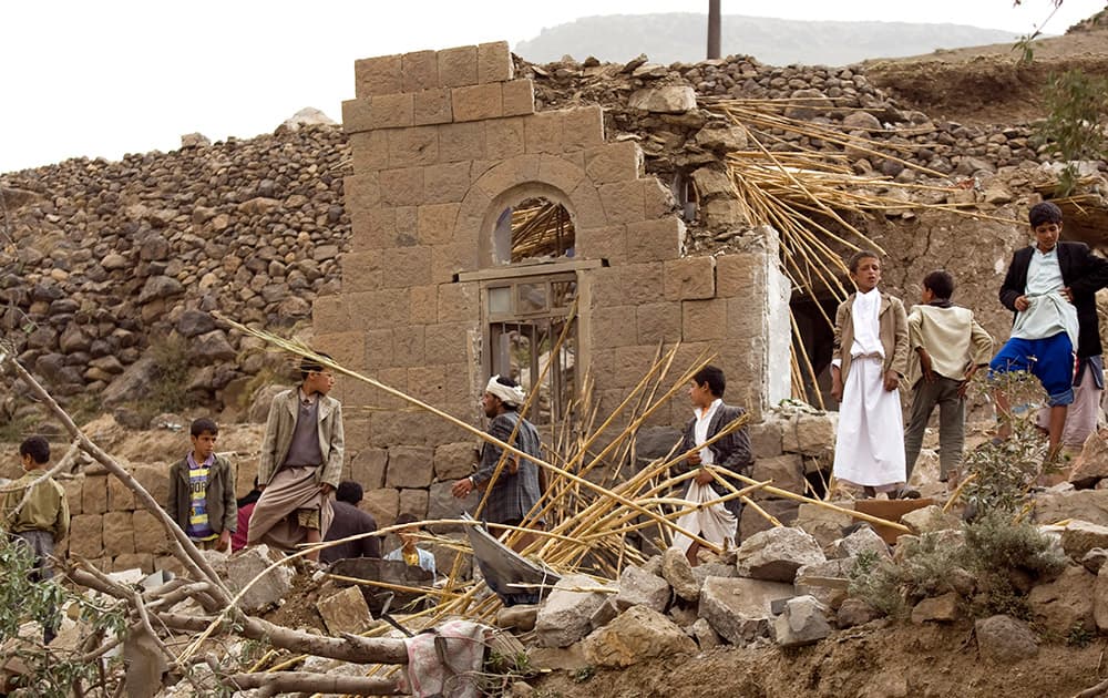 Yemenis gather as they search for survivors in the rubble of houses destroyed by Saudi-led airstrikes in a village near Sanaa, Yemen.