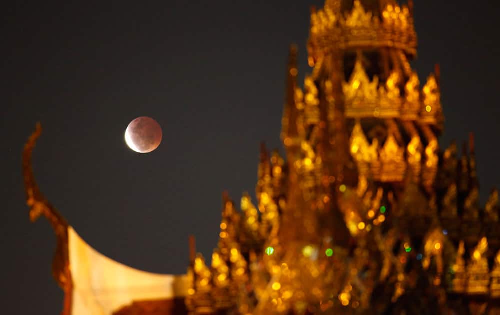 A lunar eclipse is observed behind the Plubplachai temple in Bangkok.