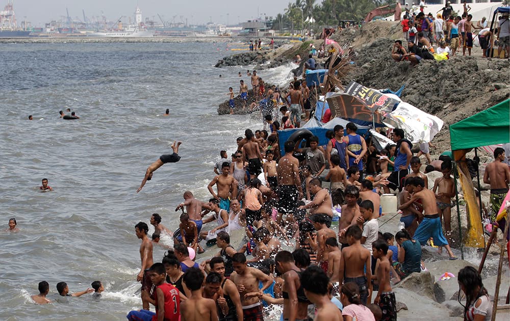 Filipinos swim in the polluted waters of Manila's bay, Philippines as they celebrate Easter.