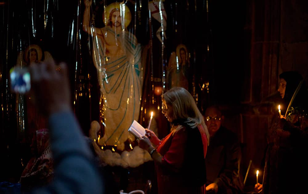 Christian worshipers pray in the Church of the Holy Sepulcher, traditionally believed by many to be the site of the crucifixion and burial of Jesus Christ, during Orthodox Palm Sunday, in Jerusalem.