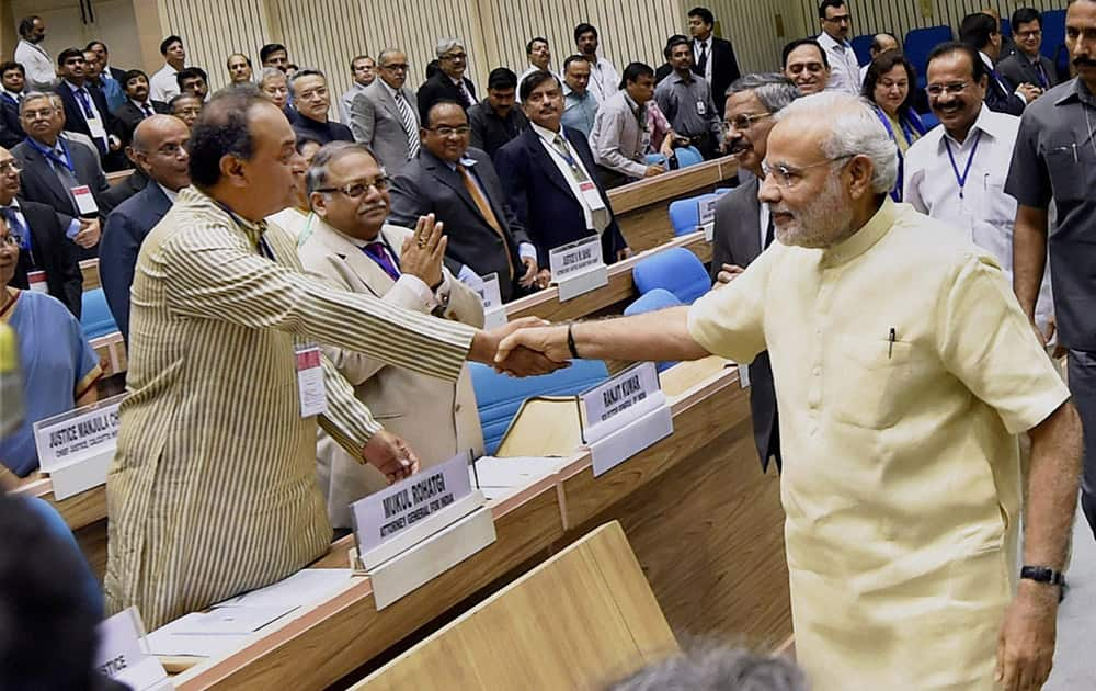 Prime Minister Narendra Modi shakes hand with Attorney General of India Mukul Rohatgi during the inauguration of the joint conference of the CMs and the CJs of High Courts at Vigyan Bhawan in New Delhi.