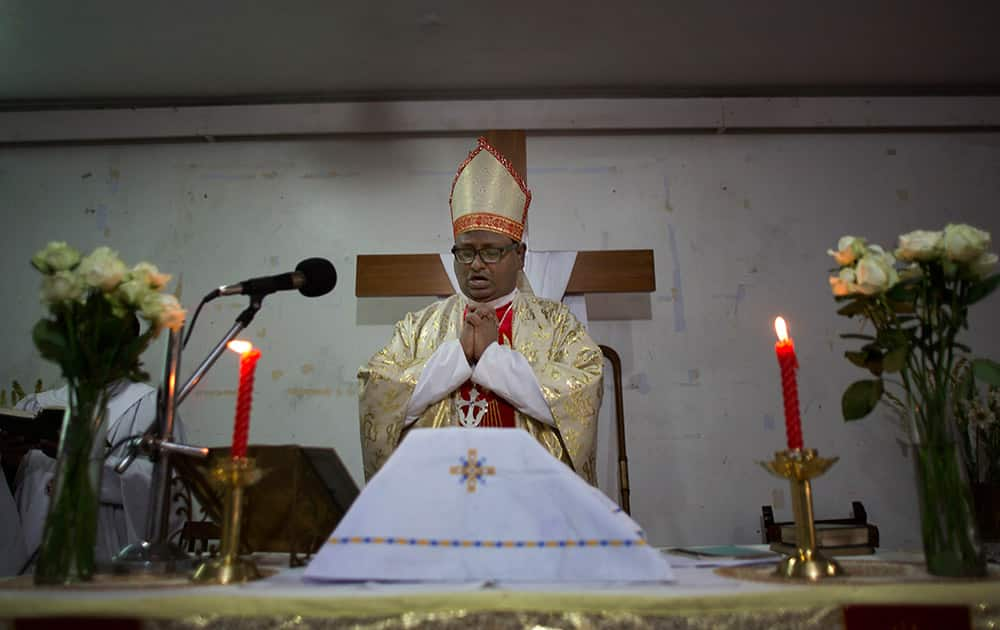 A Christian priest prays during Easter mass at a Church in Guwahati.