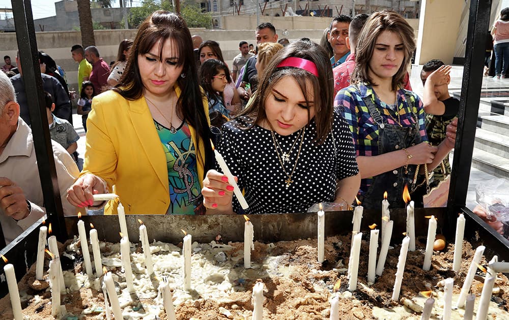 Iraqis women light candles after the Palm Sunday service at Lady Deliverance Church in Baghdad, Iraq.