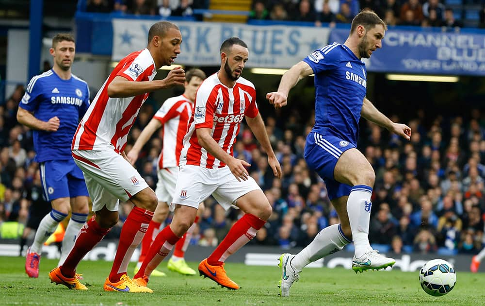 Chelsea's Branislav Ivanovic, right, controls the ball away from Stoke's players during the English Premier League soccer match between Chelsea and Stoke City at Stamford Bridge stadium in London.