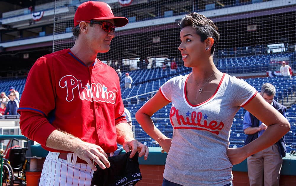 Philadelphia Phillies' Chase Utley, left, reacts to getting a pair of underwear from cancer survivor Julie Kramer, right, during warm-ups prior to the first inning of an opening day baseball game against the Boston Red Sox, in Philadelphia.