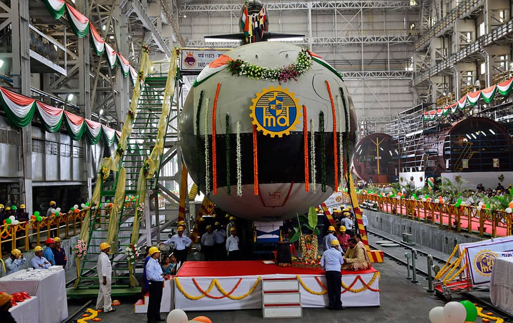 Employees stand near the Indian Navy's first indigenously-built Scorpene attack submarine at Mazagon Dock in Mumbai, India.