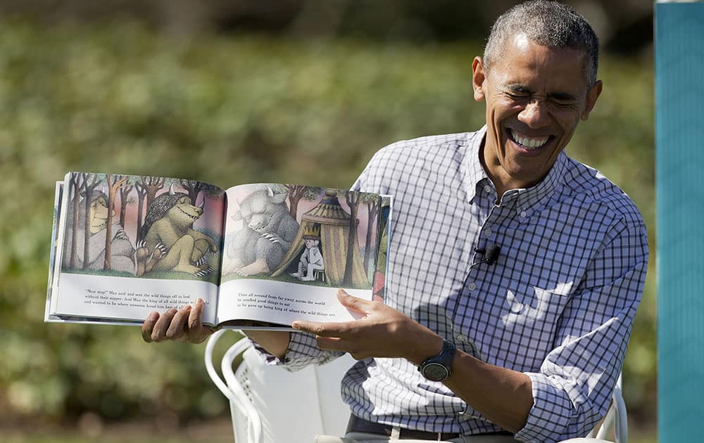 President Barack Obama begins to laugh as he reads 