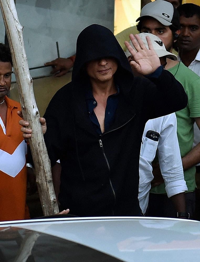 Bollywood actor Shah Rukh Khan waves towards fans as he leaves after finishing a shoot for a film in Mumbai.