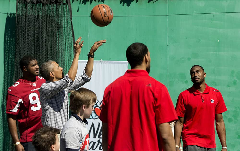 President Barack Obama shoots a basket as he plays on the basketball court on the South Lawn of the White House in Washington during the White House Easter Egg Roll.