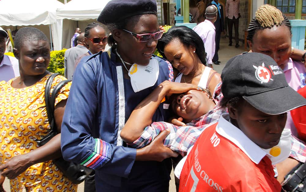 Red Cross staff console a woman after she viewed the body of a relative killed in Thursday's attack at a university in Garissa northeastern Kenya, at Chiromo funeral home, Nairobi, Kenya.