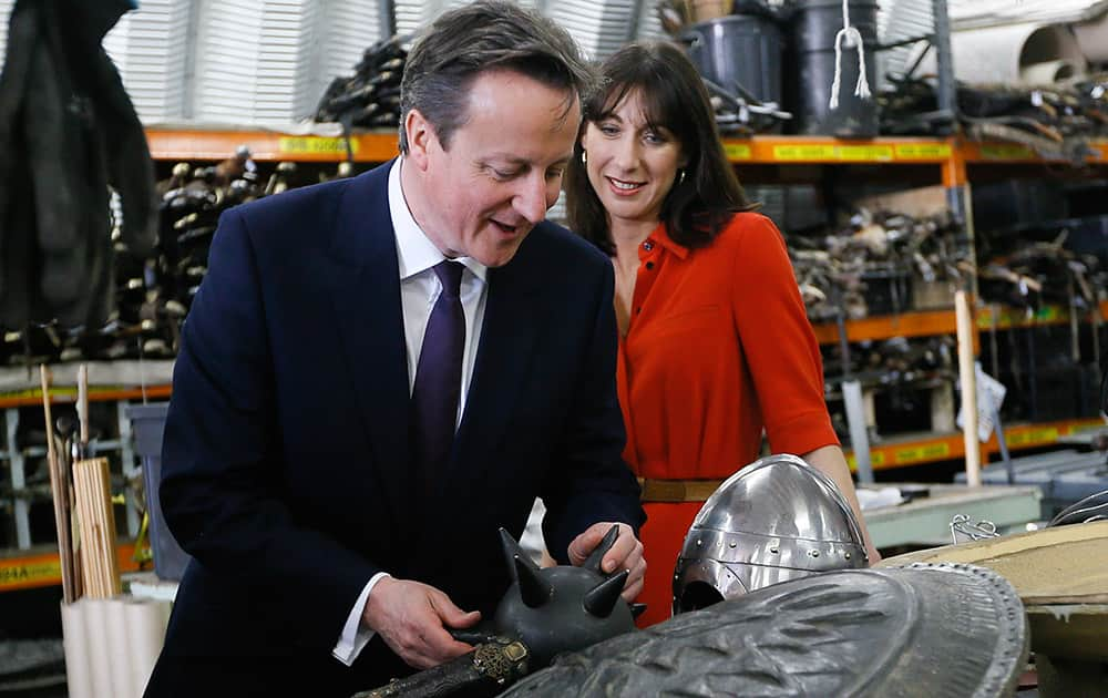 Britain's prime minister David Cameron and his wife Samantha look at a weapon in a workshop, during a visit to the popular TV fantasy drama Game of Thrones television set in Belfast, Northern Ireland. Britain goes to the polls in a General Election on May 7. 