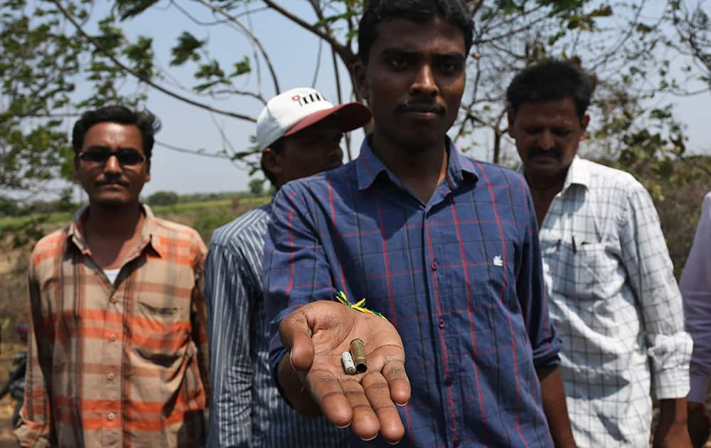 A police man displays empty cartridges near a spot where 5 prisoners who allegedly tried to escape vehicle on way to court were shot dead by police at Pembarthi village in Warangal, Telangana state.