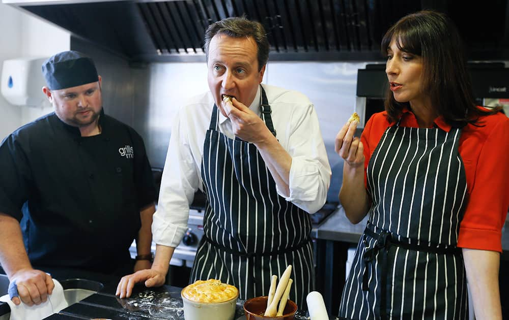 Britain's Prime Minister David Cameron tastes some pie with his wife Samantha during a visit to Brains Brewery in Cardiff, Wales. Britain goes to the polls in a General Election on May 7.