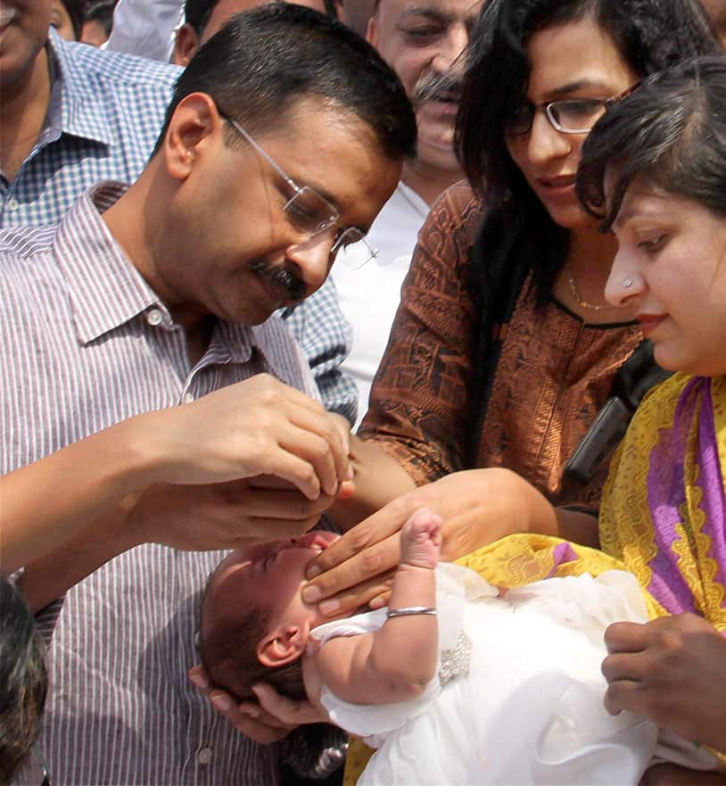 Delhi Chief Minister Arvind Kejriwal administers vaccine to a child after launch of Mission Indradhanush for giving health cover to children at Kale Khan Chowk in New Delhi.