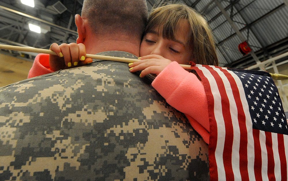 Ashley Nowakowski, 8, of Colchester Conn., hugs her father Major Stephan Nowakowski, during a deployment send off ceremony at the Connecticut National Guard base, in Windsor Locks, Conn. 