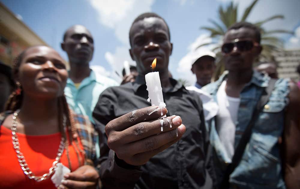 Kenyan students, some wearing black shirts to represent mourning, hold candles as they march in memory of the victims of the Garissa college attack and to protest what they say is a lack of security, in downtown Nairobi, Kenya.