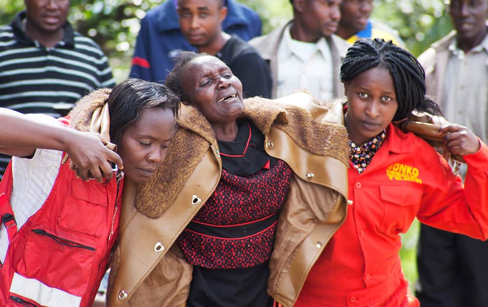 Kenya Red Cross staff help a woman after she viewed the body of a relative killed in last Thursday's attack on Garissa University College in northeastern Kenya, at Chiromo funeral home, Nairobi, Kenya.