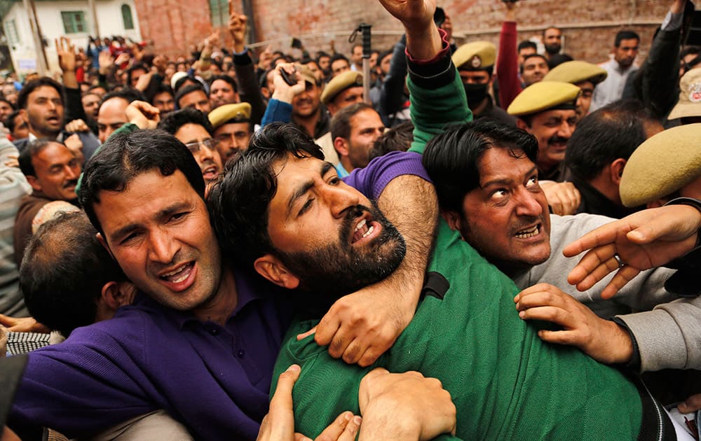 Jammu and Kashmir state government teachers hold each other to resist against policemen trying to detain them during a protest in Srinagar.
