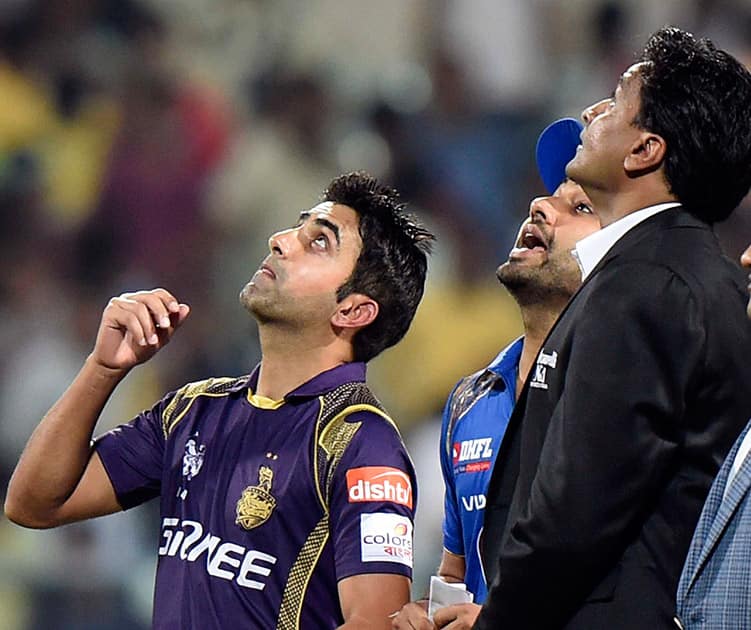 KKR skipper Gautam Ghambhir spins the coin as MI skipper Rohit Sharma and match referee Javagal Srinath look at Eden Gardens.